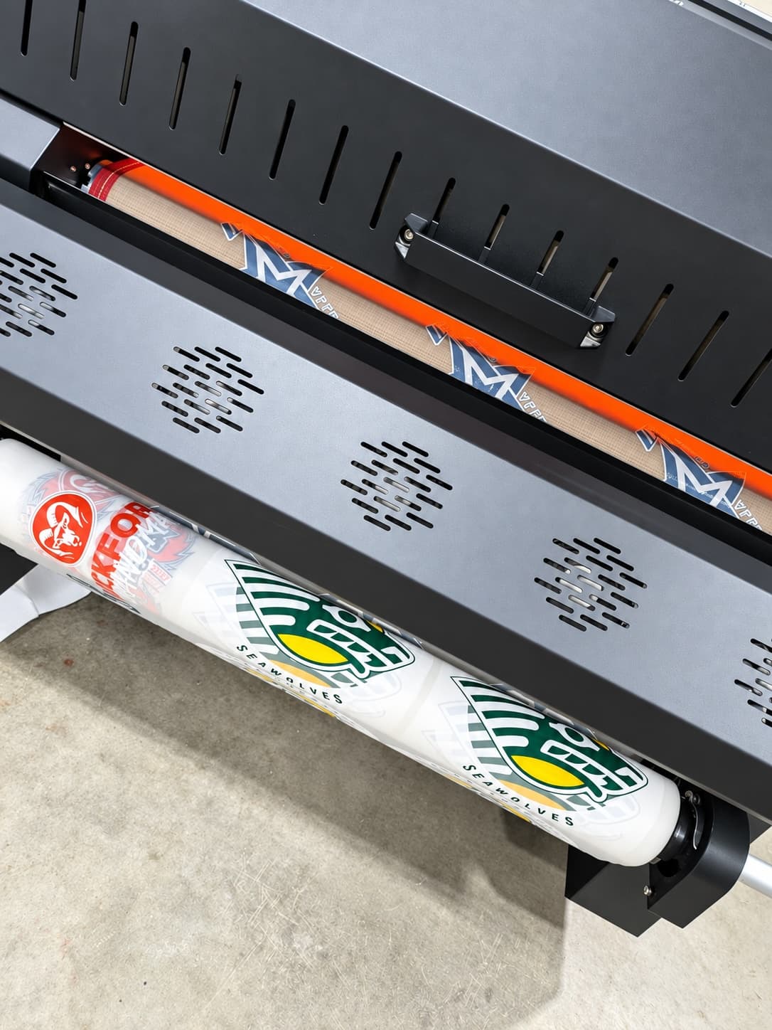 Printed film feeding through the powder shaker and curing oven